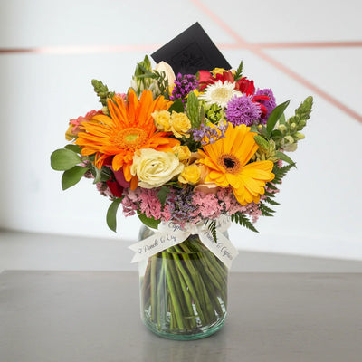 Arreglo floral de Gerberas Mix, Rosas, Boca de Dragón y Estate Morada -GI025-