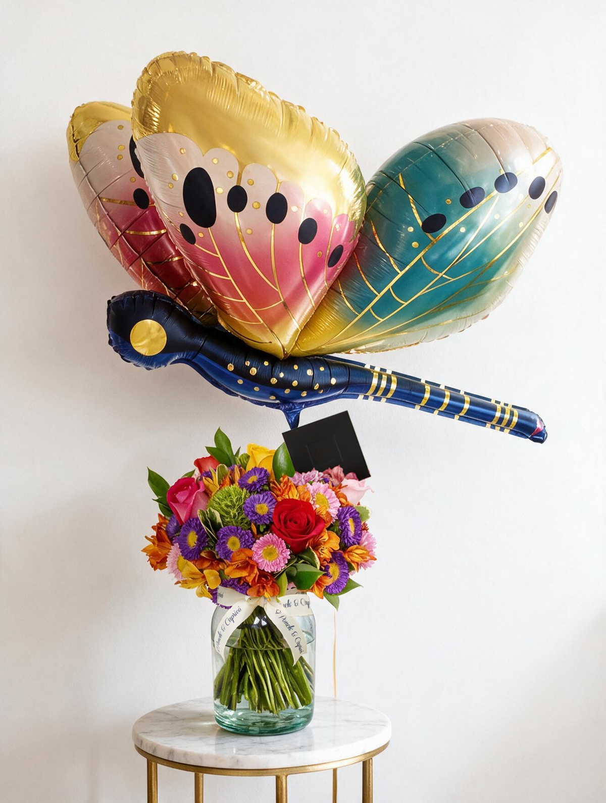 Set de regalo: arreglo floral de rosas mix y matsumoto en florero de vidrio junto a un globo libélula dragonfly gigante con helio