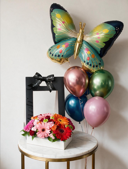 Set de regalo: canasta de gerberas de colores y mini rosas junto a un bouquet de globos con mariposa azul gigante y cinco globos cromo con helio