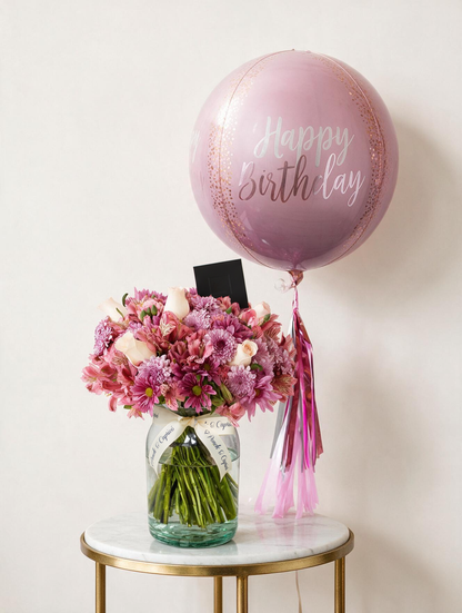 Set de regalo: arreglo floral de rosas, margaritas y alstromelias en tonos rosas junto a un globo orbz rosa blush Happy Birthday con tassel e inflado con helio