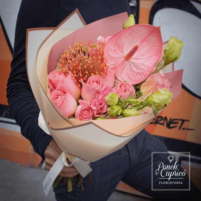 Lindo ramillete atado a mano de Rosa Hermosa, Lisianthus Durazno y Leucus Naranja, además de Aquilea Melón y Anturio Rosado con Blanco; envuelto en elegante papel y delicado moño pequeño de tela.